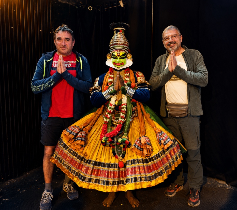 Travelers with a Kathakali performer in traditional costume and makeup, Kerala