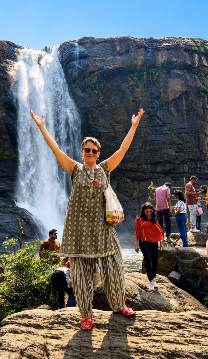 Voyageuse celebrant devant les chutes d'Athirapally en pleine mousson, Kerala