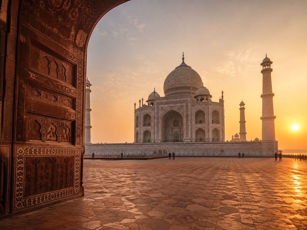 The Taj Mahal at sunrise, viewed through the Great Gate with its dome and minarets